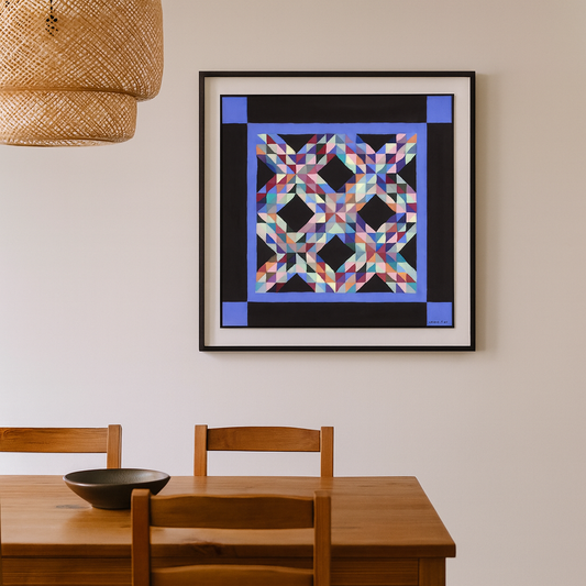 Framed colorful geometric art piece on a wall above a wooden dining table.