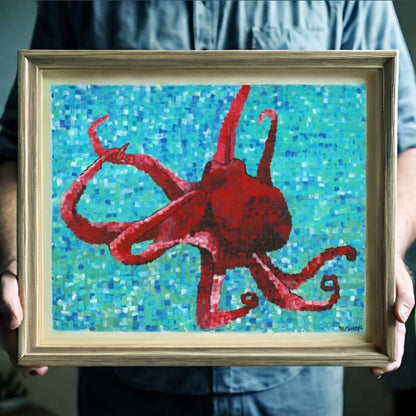 A person holding a framed octopus painting, an intriguing artwork on a canvas print.