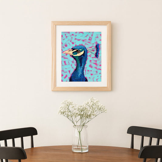 Framed artwork of a peacock on a wall above a table with a vase of flowers.