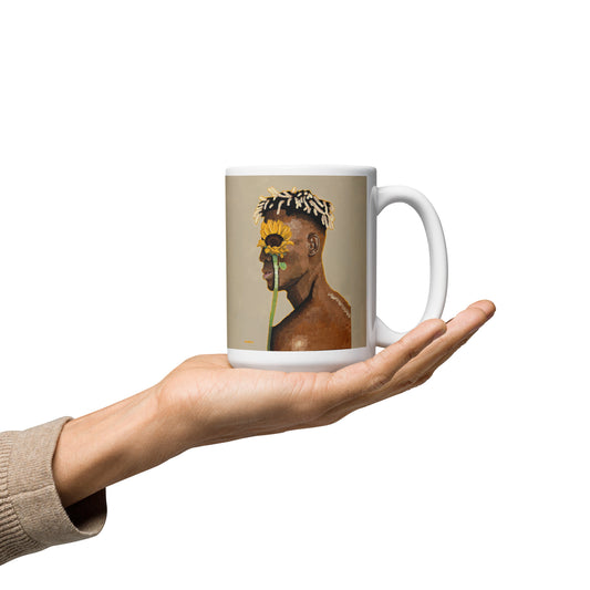 Mug with a design of a person holding a sunflower, held in a hand against a white background