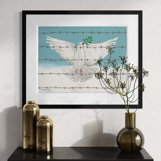 Framed peace dove art print displayed on wall above dark console table with gold vases and dried botanical