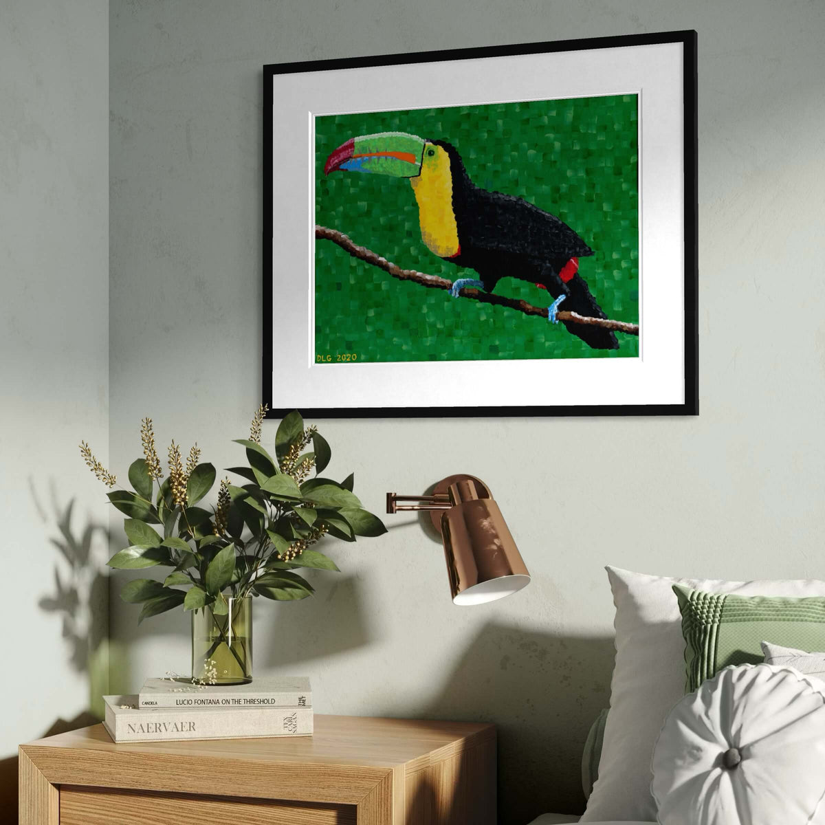 Framed toucan wall art hanging above a bedroom nightstand