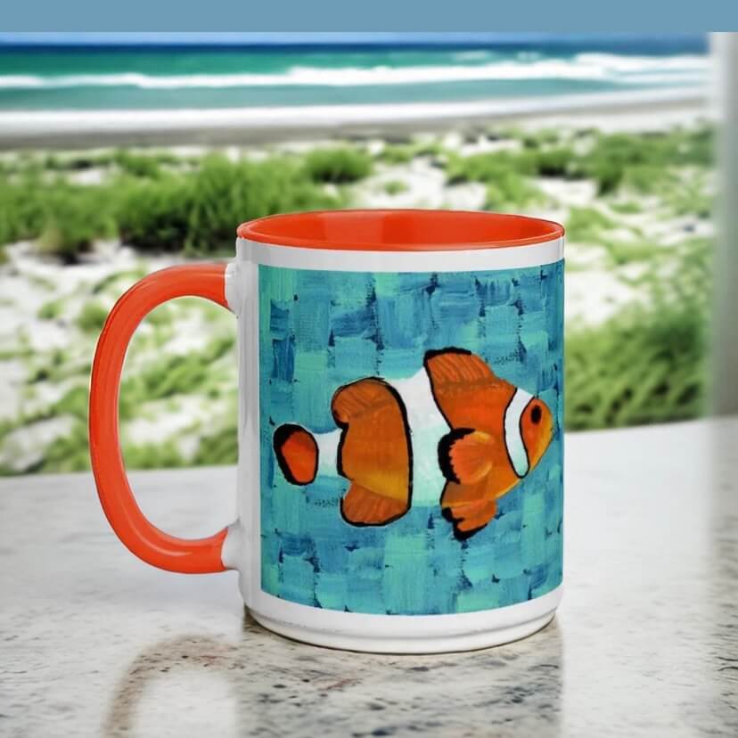 An adorable clownfish with orange and black stripes happily swims on a coffee mug. So cute!