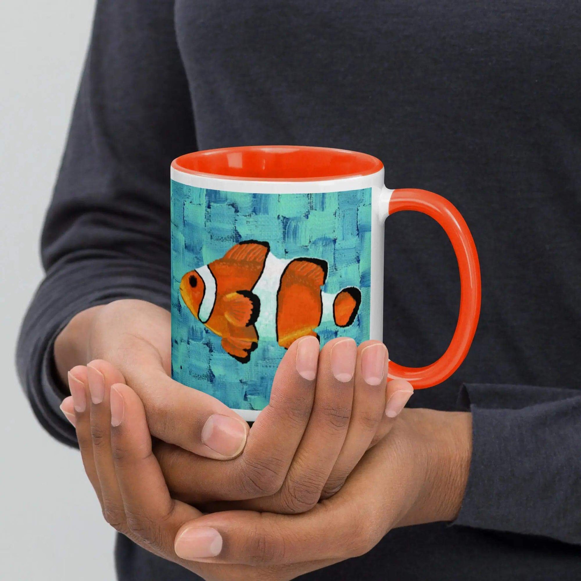 A person holding a clown fish mug, with a cute clownfish design on it. Perfect for fish lovers!