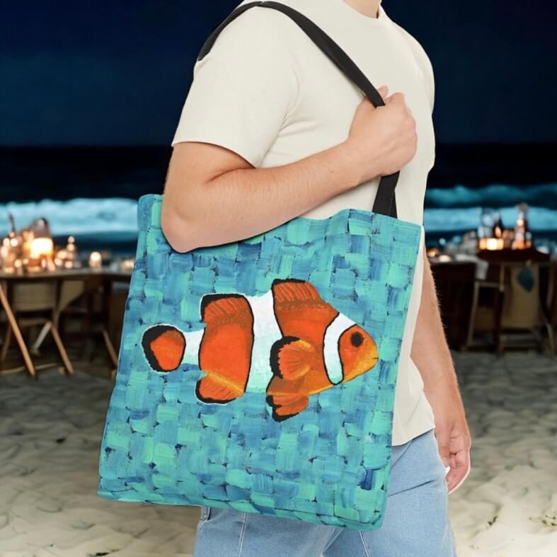 A guy at a beach party holds a tote bag with a clownfish image. It's a cool accessory for the occasion! #BeachPartyVibes