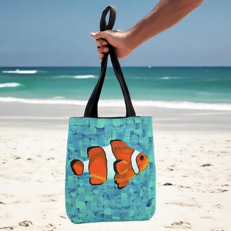 Image of clown fish on tote bag held by person.
