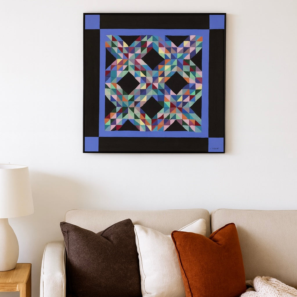 Colorful quilt hanging on a wall above a sofa with decorative pillows.