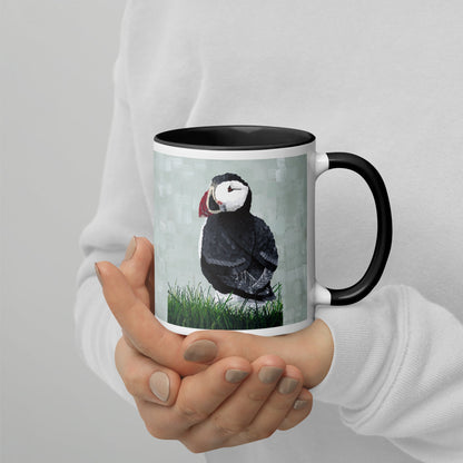 A person holding a Puffin 1 Mug with a bird artwork, perfect for enjoying your favorite beverage in style.