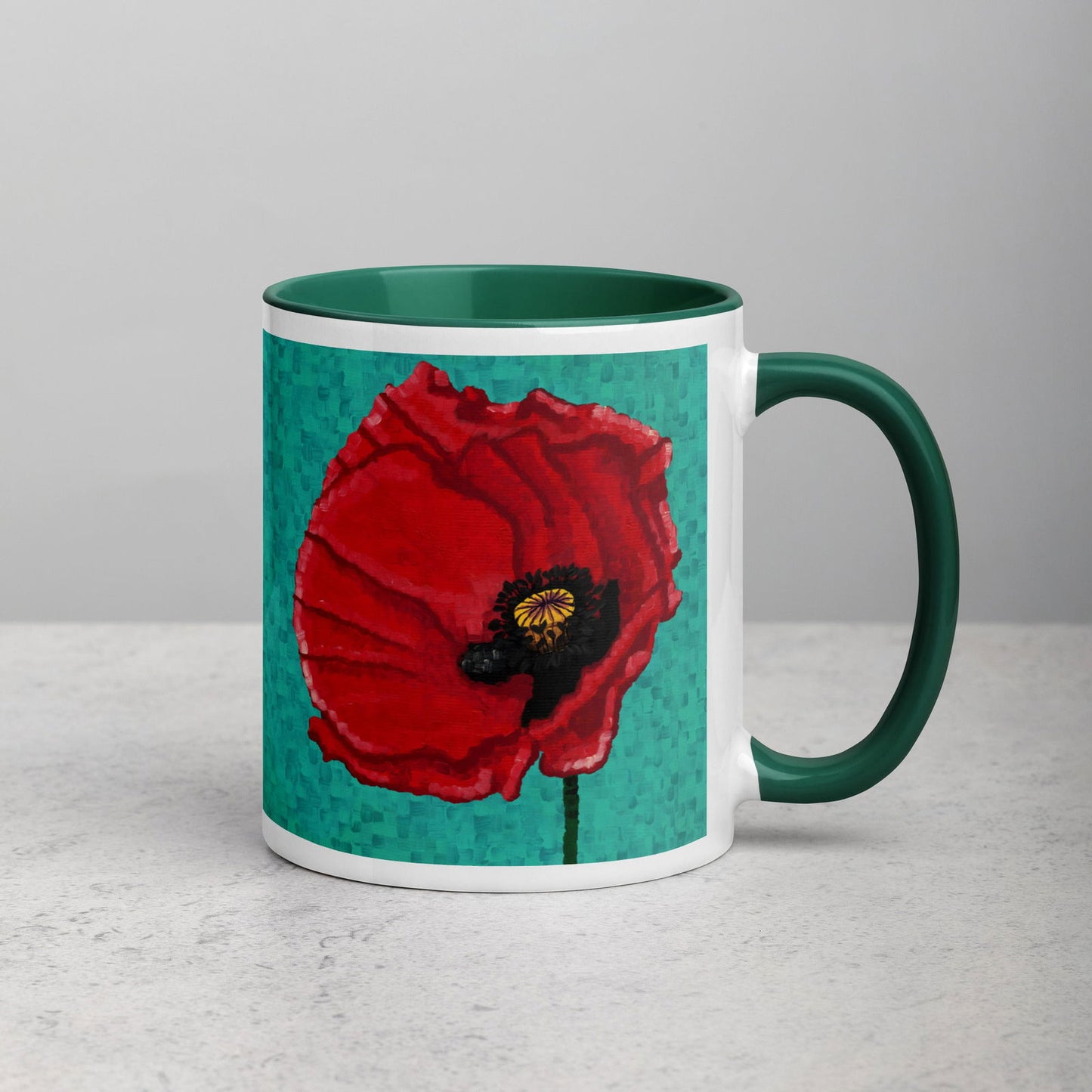 A ceramic mug with a green rim and handle, featuring a vibrant red poppy flower design on the front.