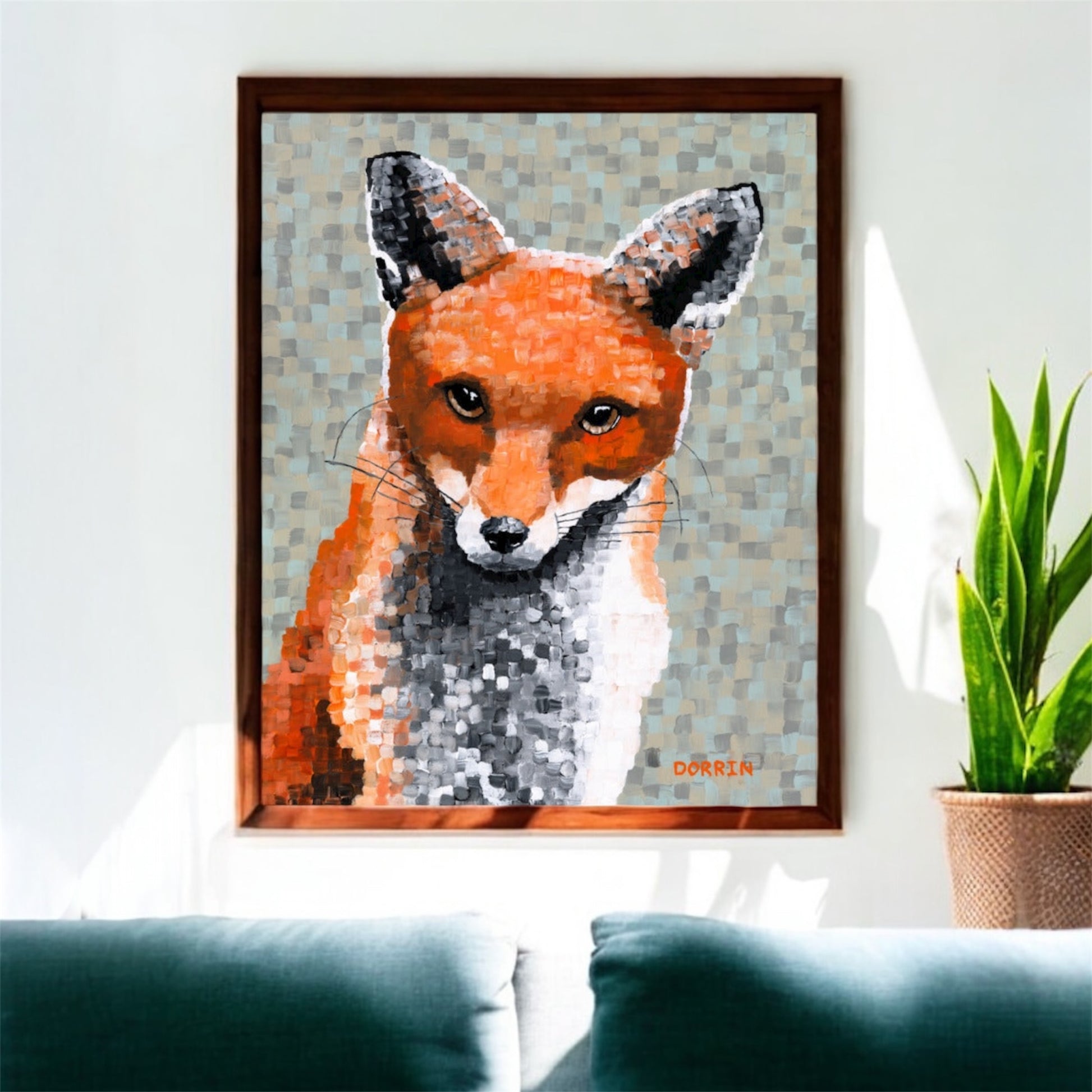 Framed artwork of a fox on a wall above a couch with a plant in the background