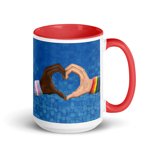 Close-up of the Loving Pride mug showing two hands forming a heart — a symbol of love in art and LGBTQ identity captured in vibrant design.