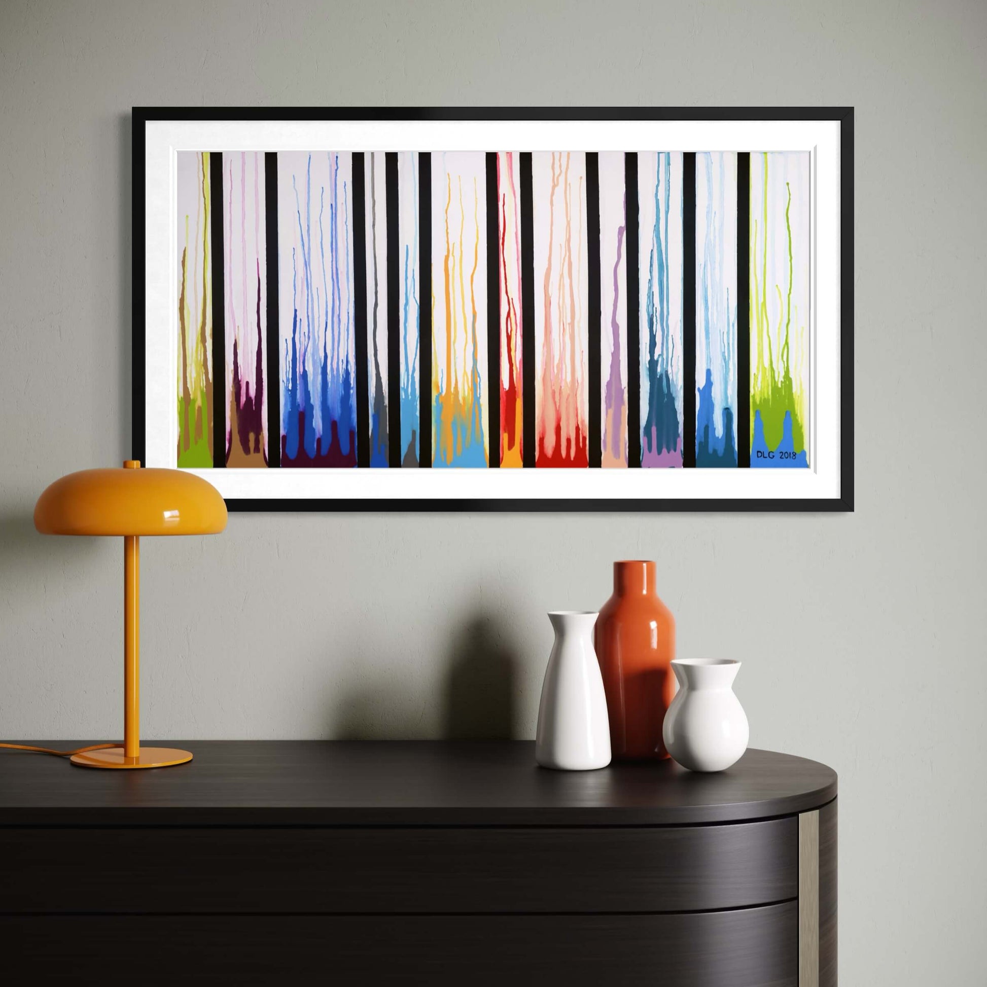 Framed Colors Rising print on a gray wall with a mustard lamp and ceramic vases