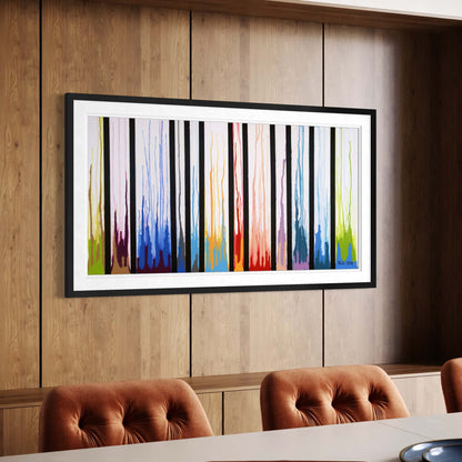 Framed Colors Rising abstract print on a wood paneled wall beside orange chairs