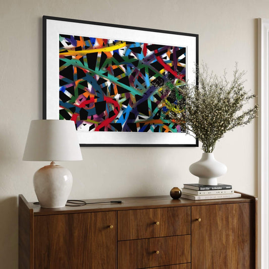 Framed Cross Roads print above a wood dresser styled with a lamp and plant