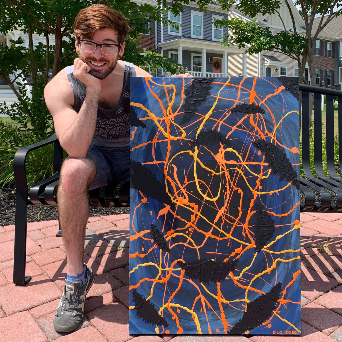 Artist sitting outdoors holding the original Darkness Conspiers 2 painting on a park bench