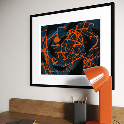 Darkness Conspires 1 abstract print above a home office desk with an orange lamp