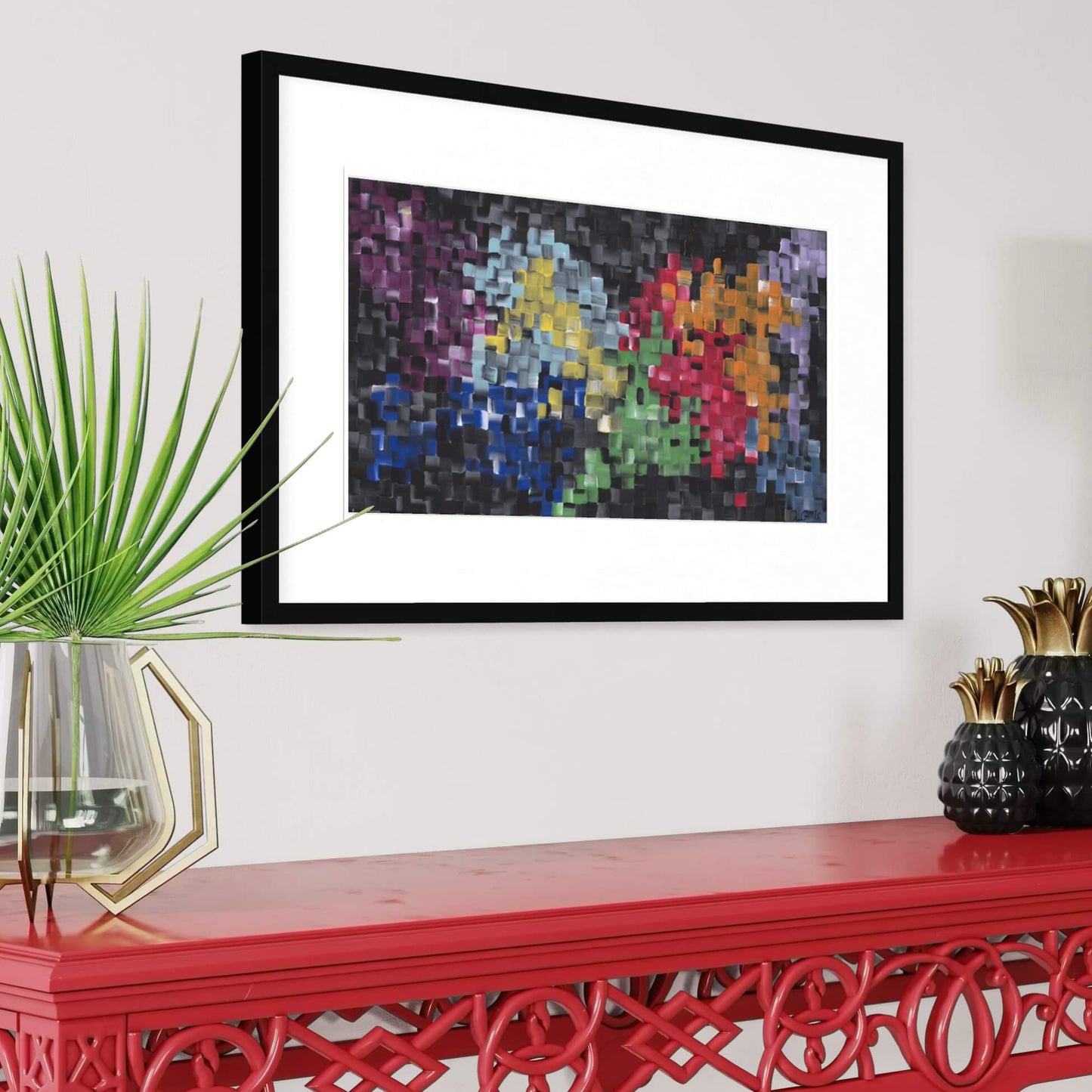 Framed First art print displayed on a red console table with a potted palm