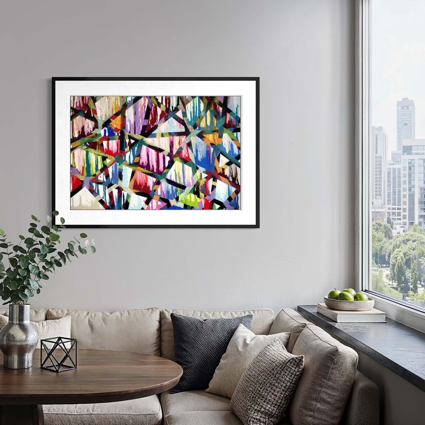 Framed Intersections abstract print above a sofa with a city skyline view