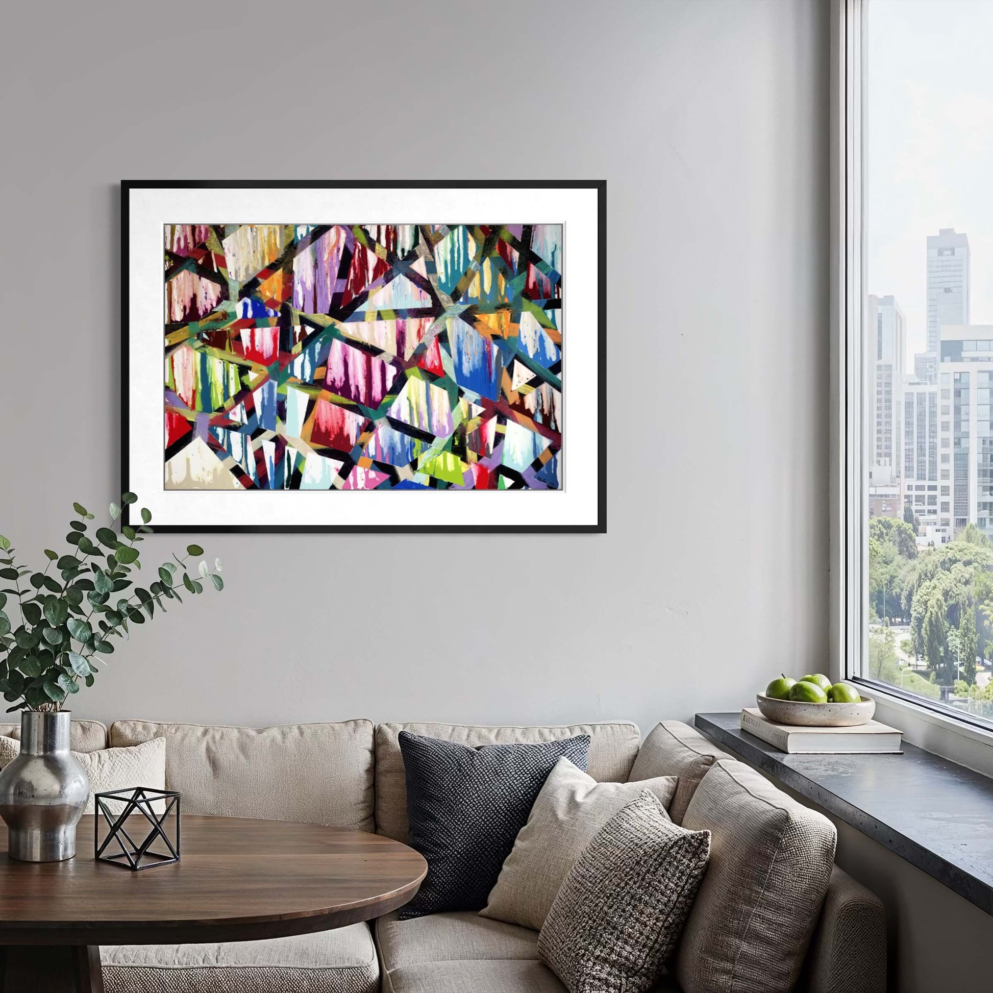 Framed Intersections abstract print above a sofa with a city skyline view