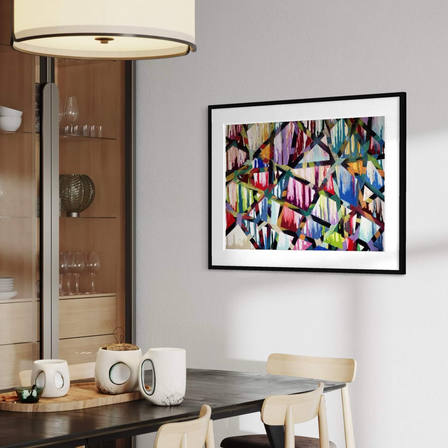 Framed Intersections print in a dining room beside a glass cabinet and lamp