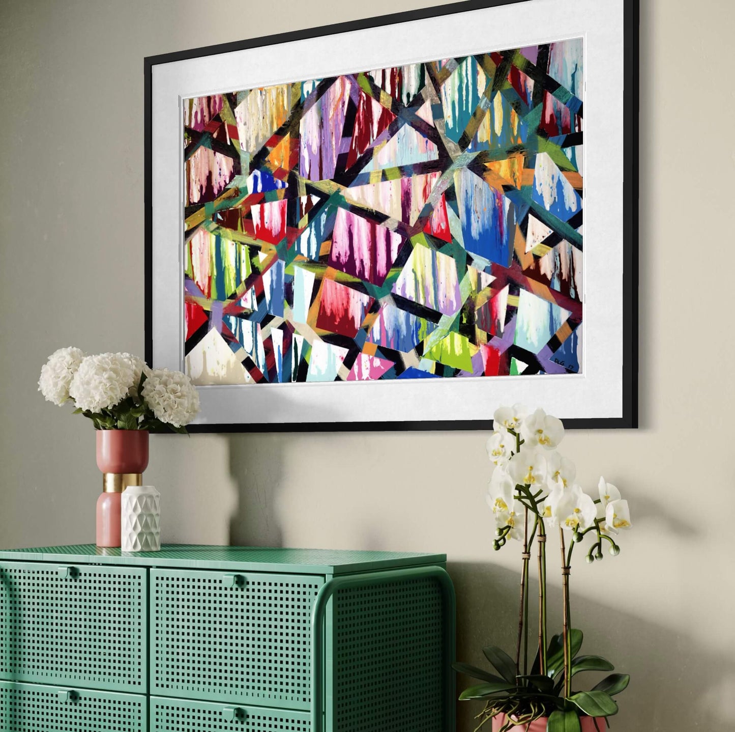 Framed Intersections abstract print angled above a green cabinet with orchids