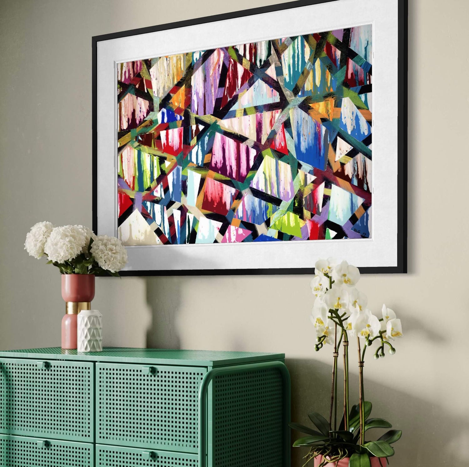 Framed Intersections abstract print angled above a green cabinet with orchids