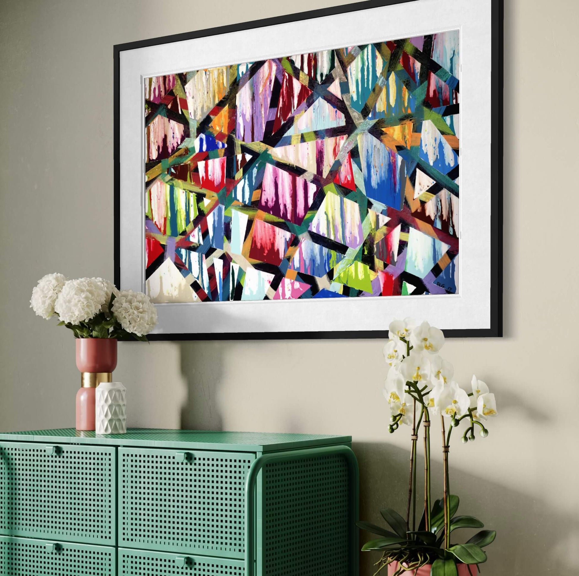 Framed Intersections abstract print angled above a green cabinet with orchids