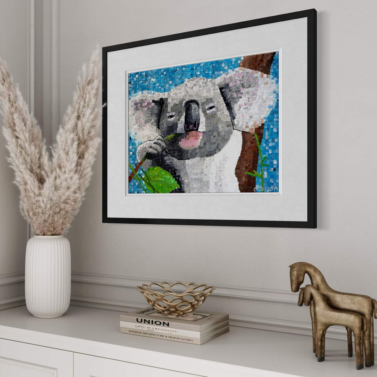 Koala art print framed and styled above a dresser with pampas grass and books