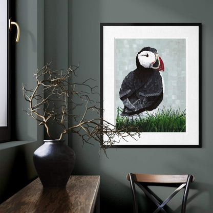 Puffin bird art in black frame on dark green wall, moody coastal home decor