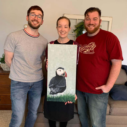 Collectors holding original puffin painting by Dorrin Gingerich, wildlife art commission