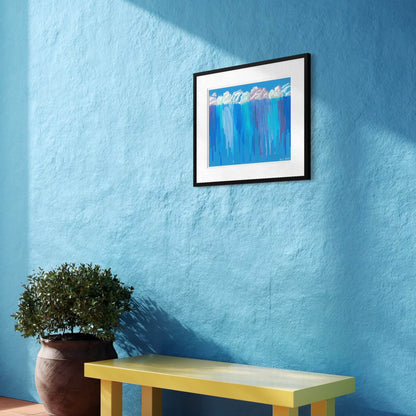 Framed Rain on Me print on a textured blue wall above a yellow bench