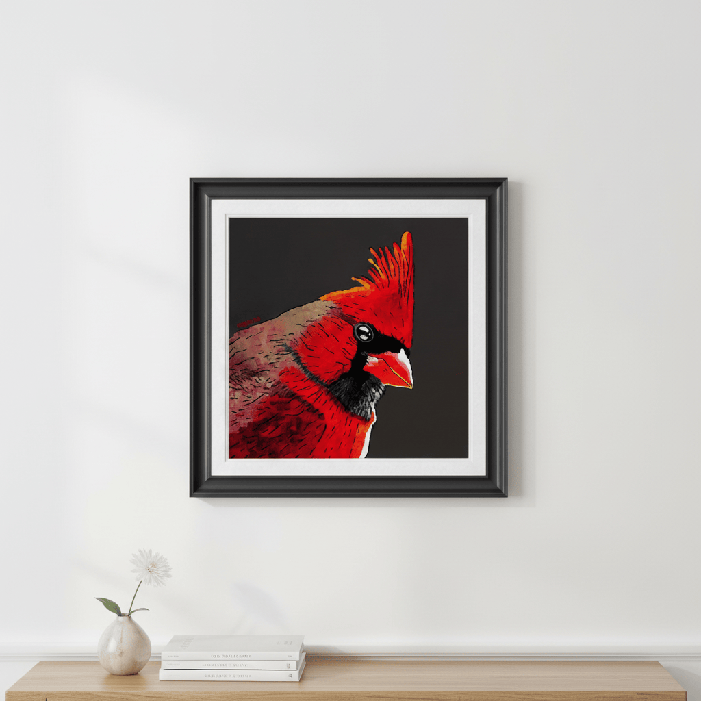 Framed red cardinal bird art print with black background hung on light gray wall above minimalist console with books and vase