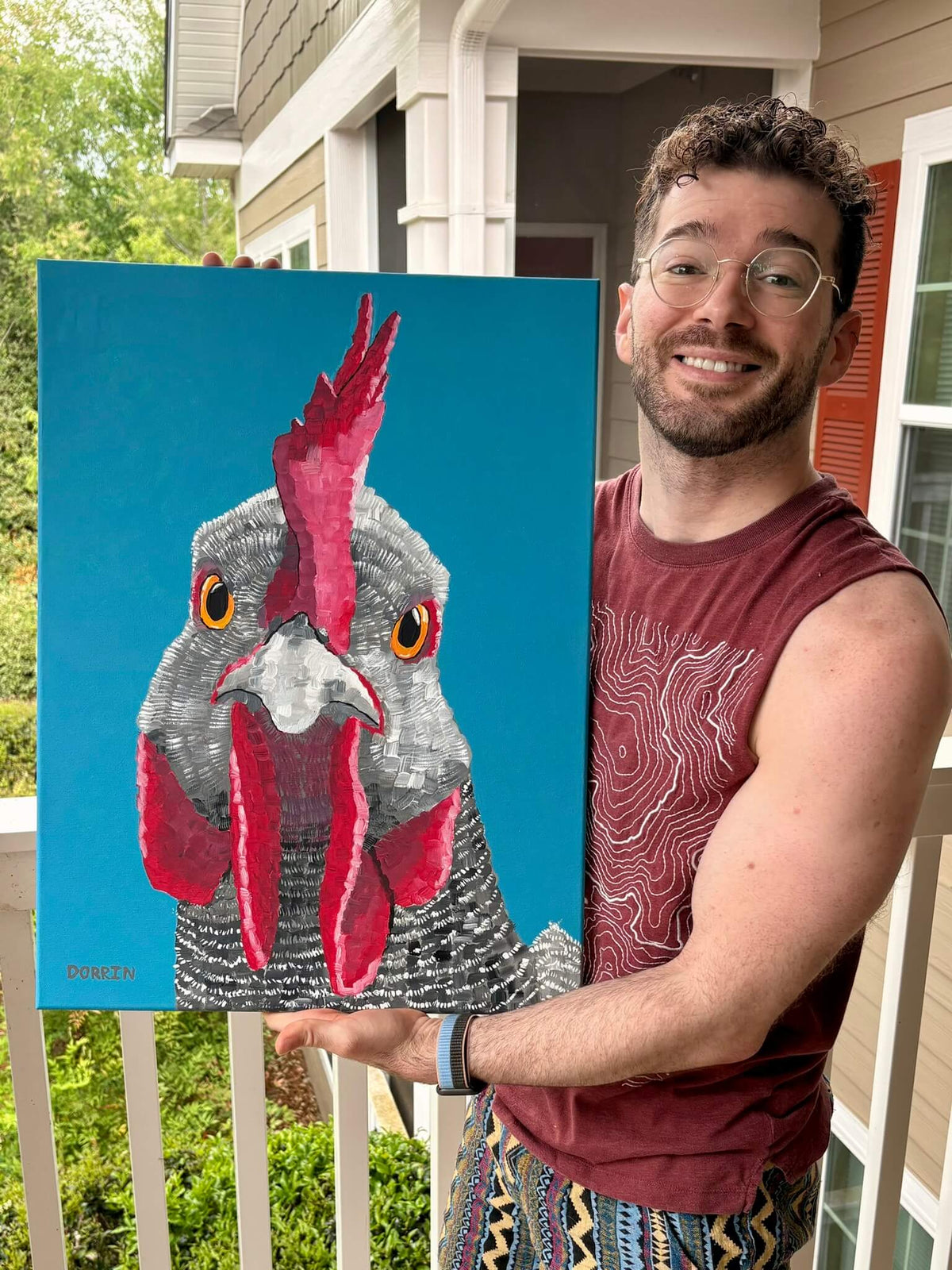 Dorrin Gingerich holding the original Rooster painting on a front porch