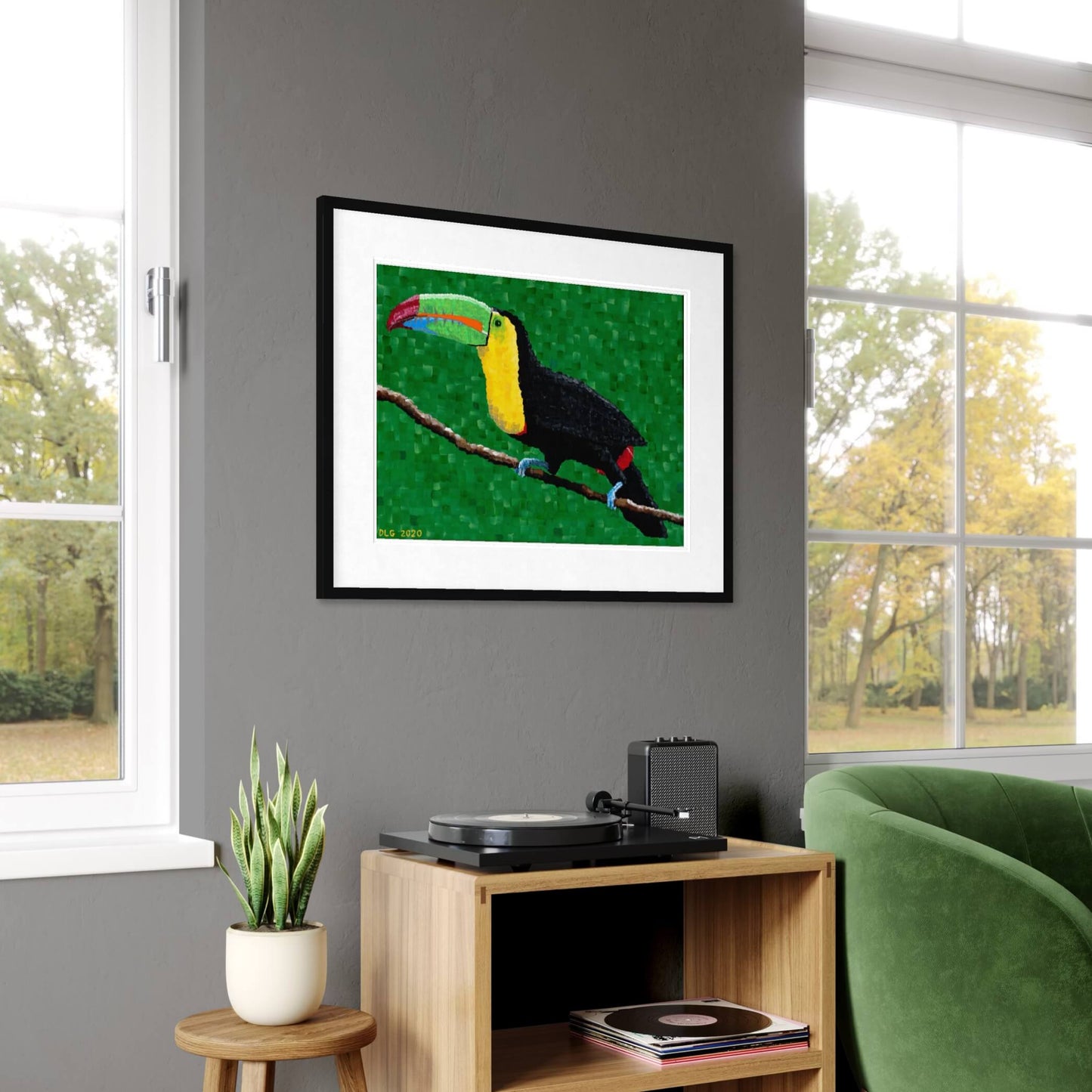Framed toucan print hanging in a living room near a turntable