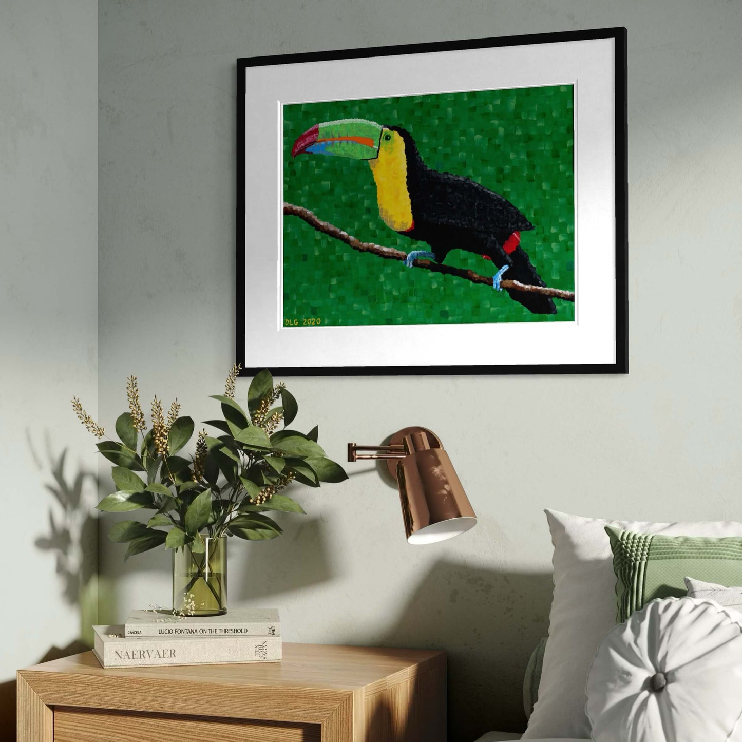 Framed toucan wall art hanging above a bedroom nightstand