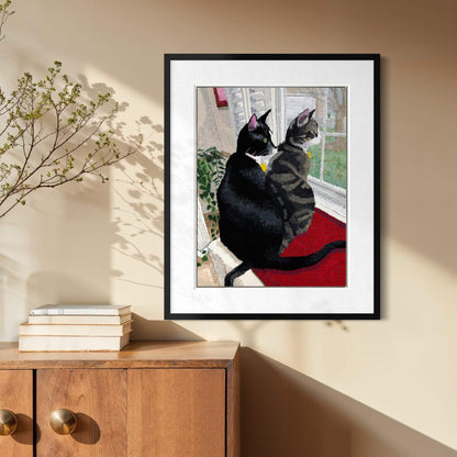 Framed cat print hanging above a wood console table in a sunlit entryway